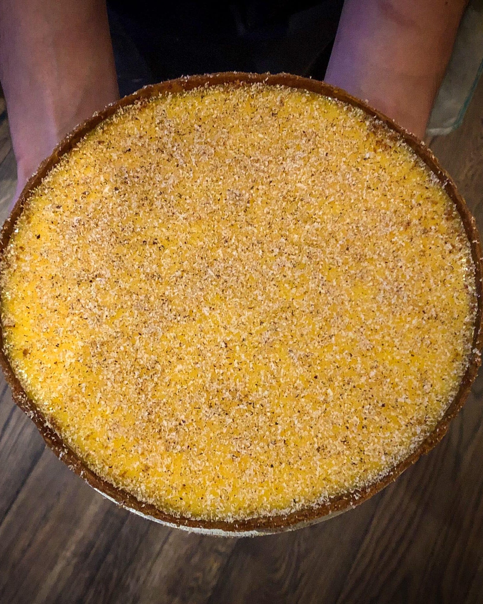 Round custard tart on a wooden surface
