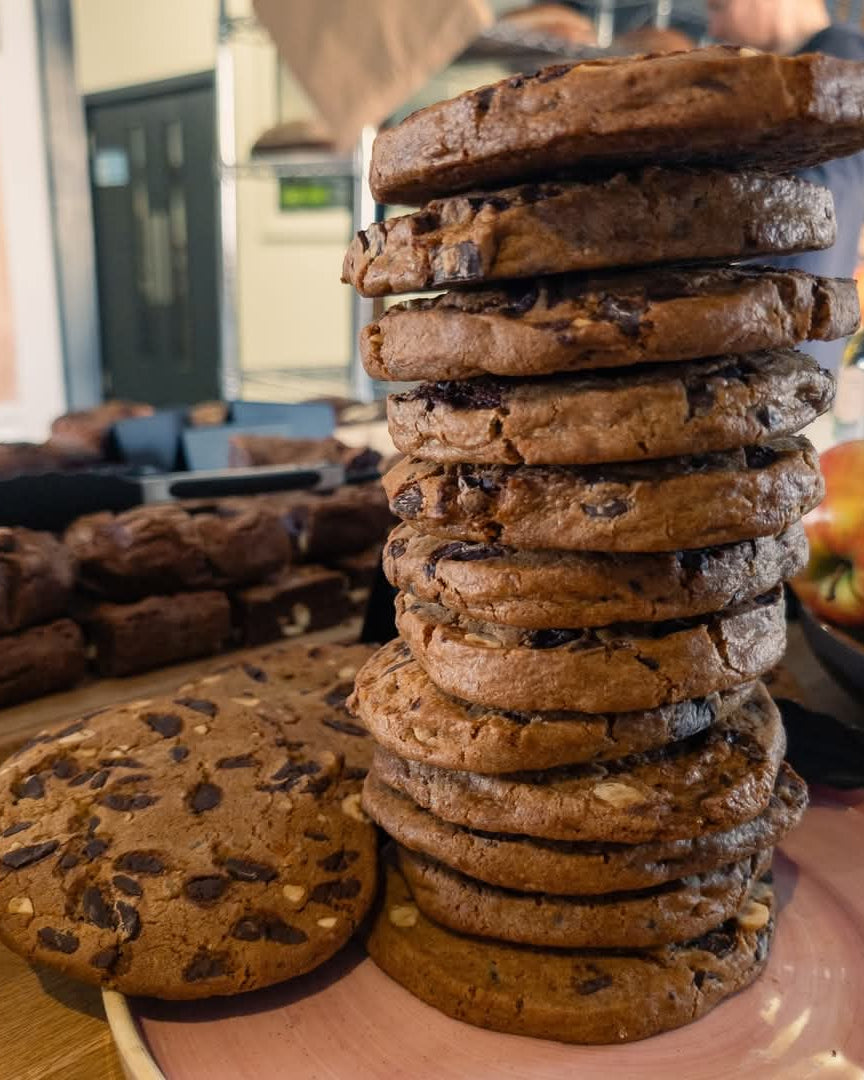 Stack of chocolate chip cookies on a wooden surface with blurred background